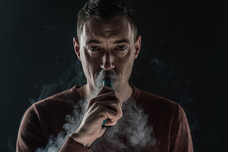 man vaping black background