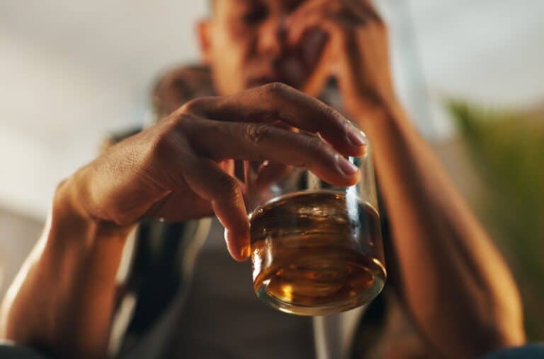 man holding glass of alcohol
